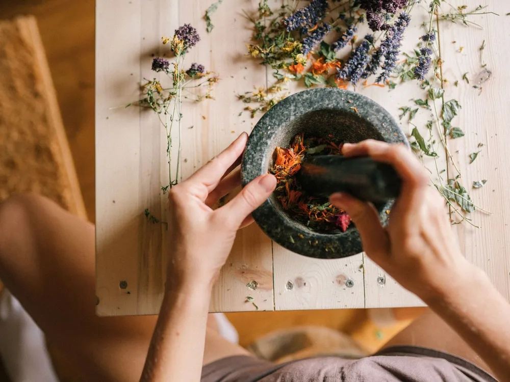 Grinding dried herbs with a mortar and pestle