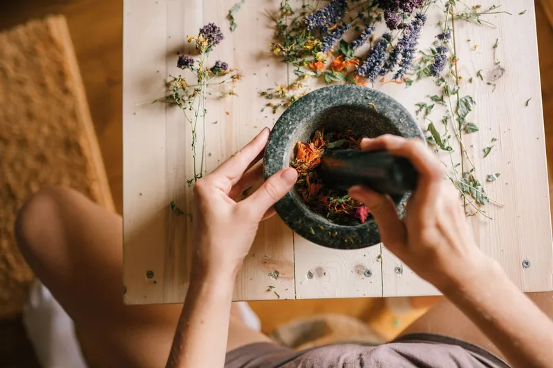 Grinding dried herbs with a mortar and pestle