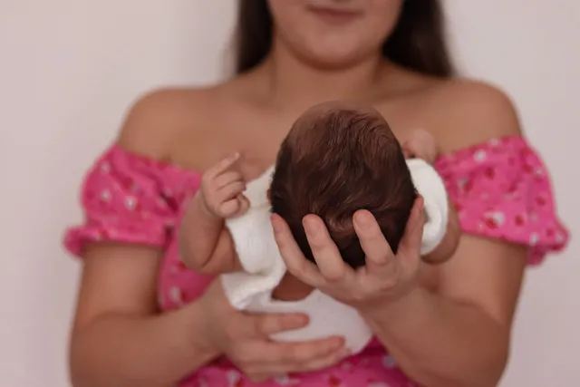 A mother cradling her newborn baby against her chest